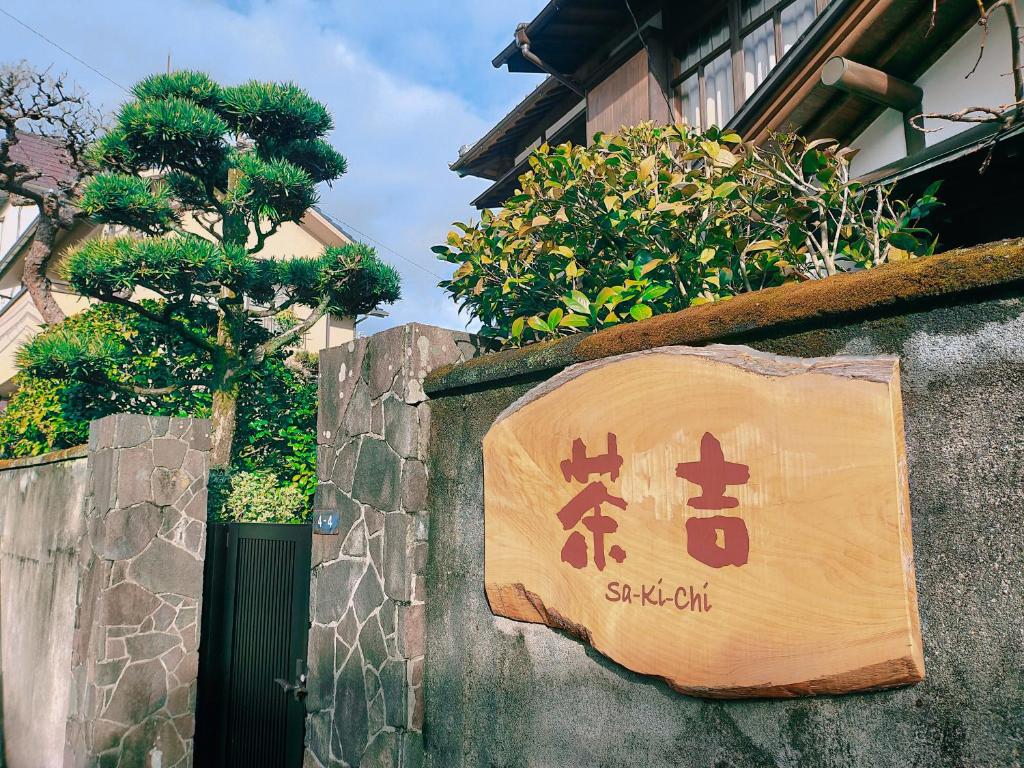 una señal en el costado de una pared en Guesthouse Sakichi en Beppu