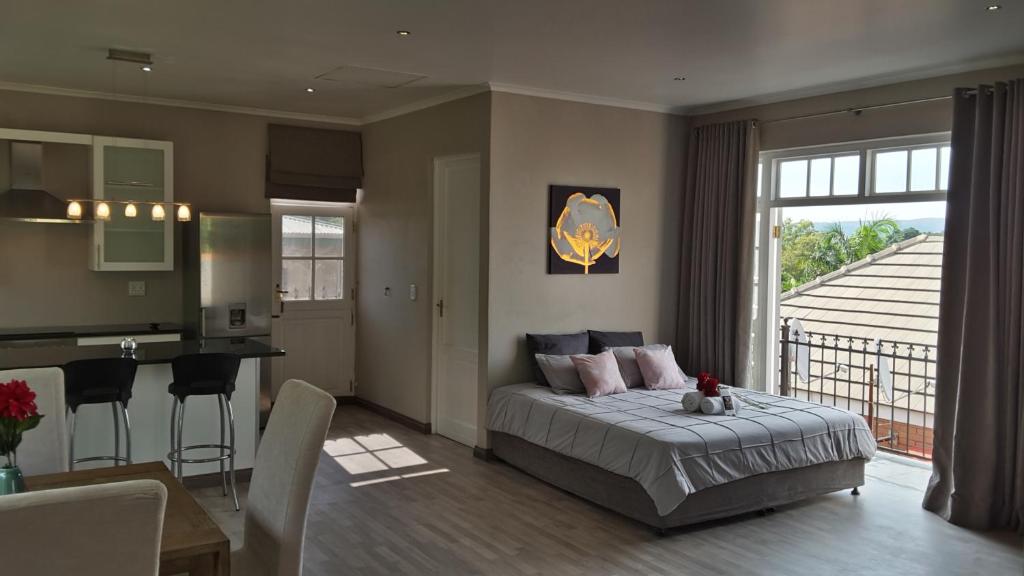 Cet appartement comprend une chambre avec un lit, une cuisine et une table. dans l'établissement Versailles, à Pretoria