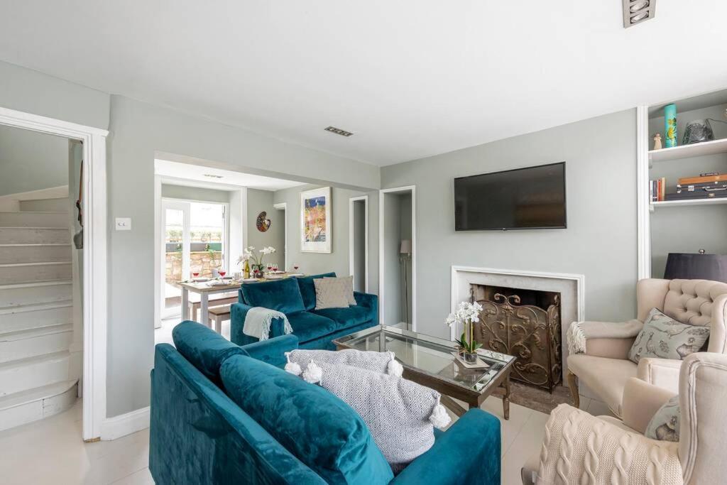 a living room with blue couches and a fireplace at Lovely 4 Bedroom townhouse in Bath