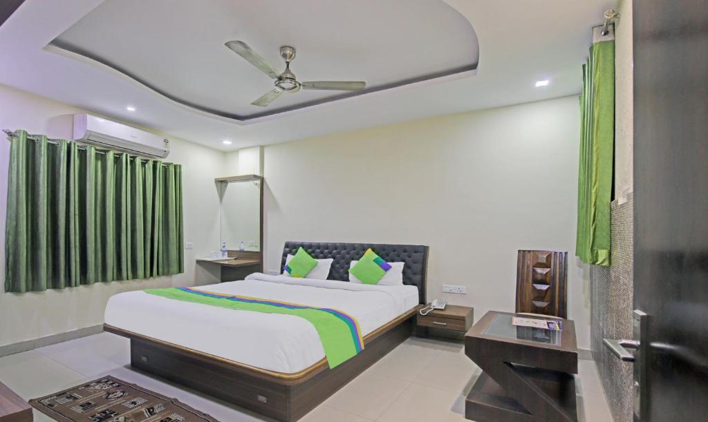 ein Schlafzimmer mit einem Bett und einem grünen Vorhang in der Unterkunft Treebo Trend Archie Regency in Ranchi