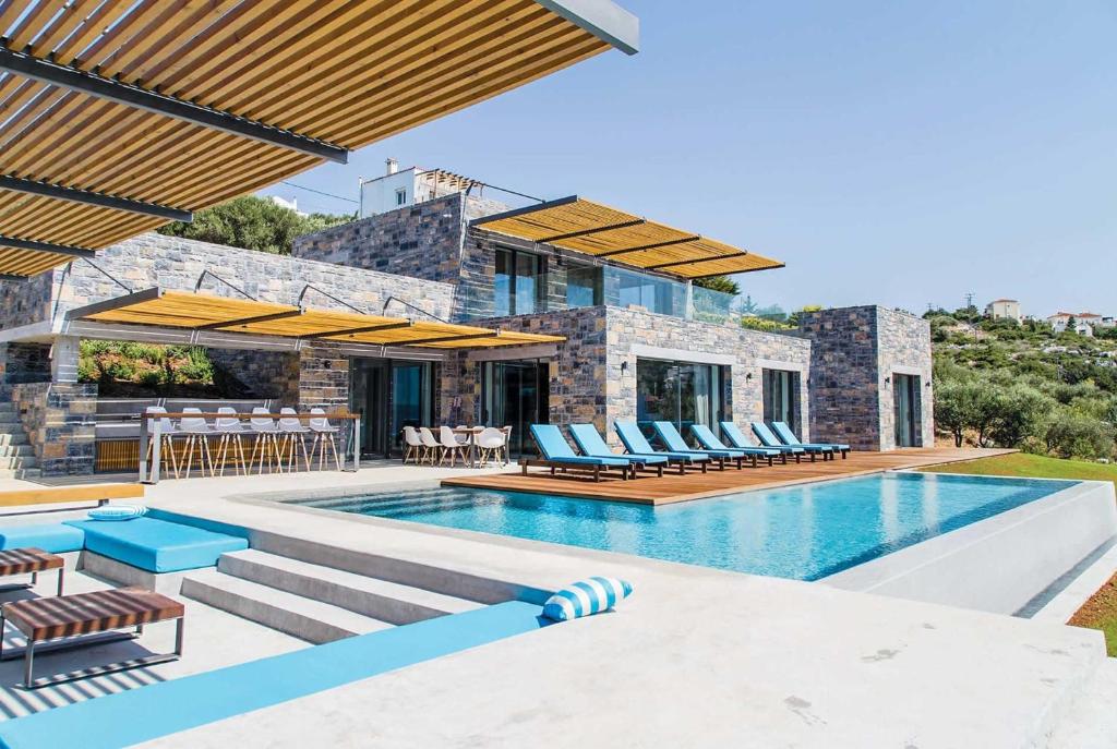 a villa with a swimming pool and patio furniture at Ektoras in Plaka