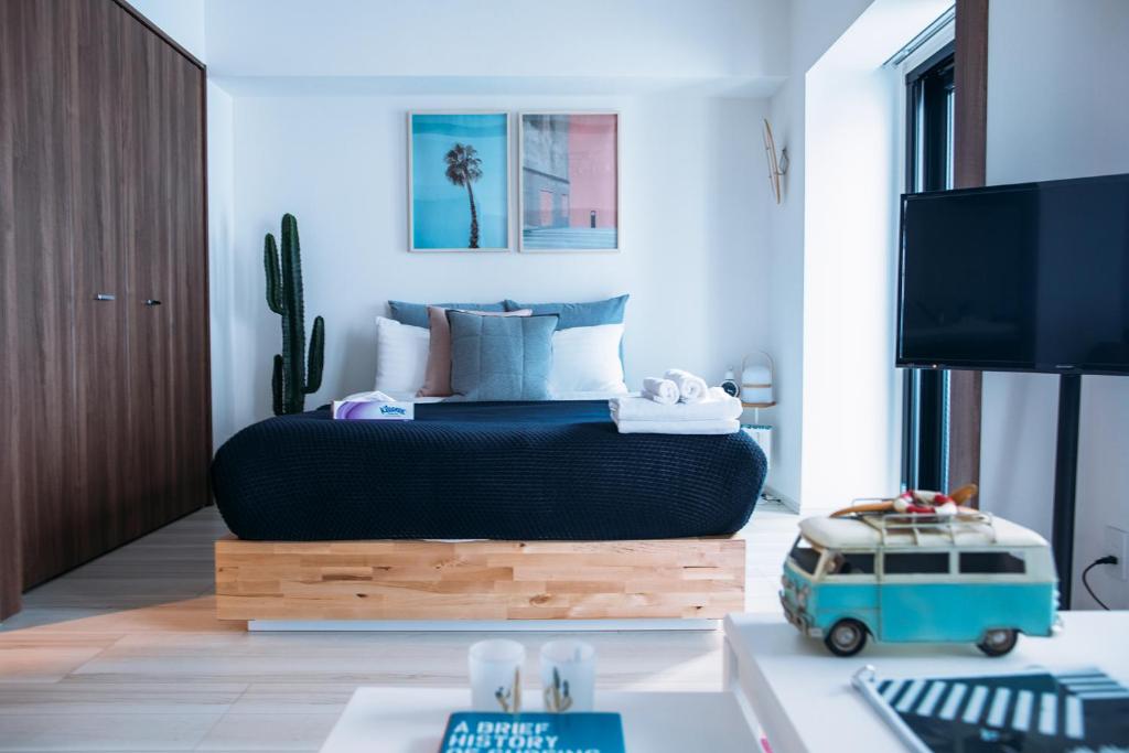 a bedroom with a bed and a tv and a table at Section L Asakusa East in Tokyo