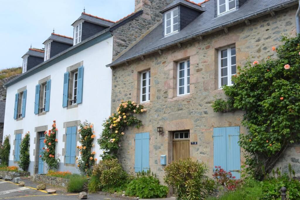a stone house with blue doors and windows at Charmante maison 19e sur le port de Dahouet in Pléneuf-Val-André