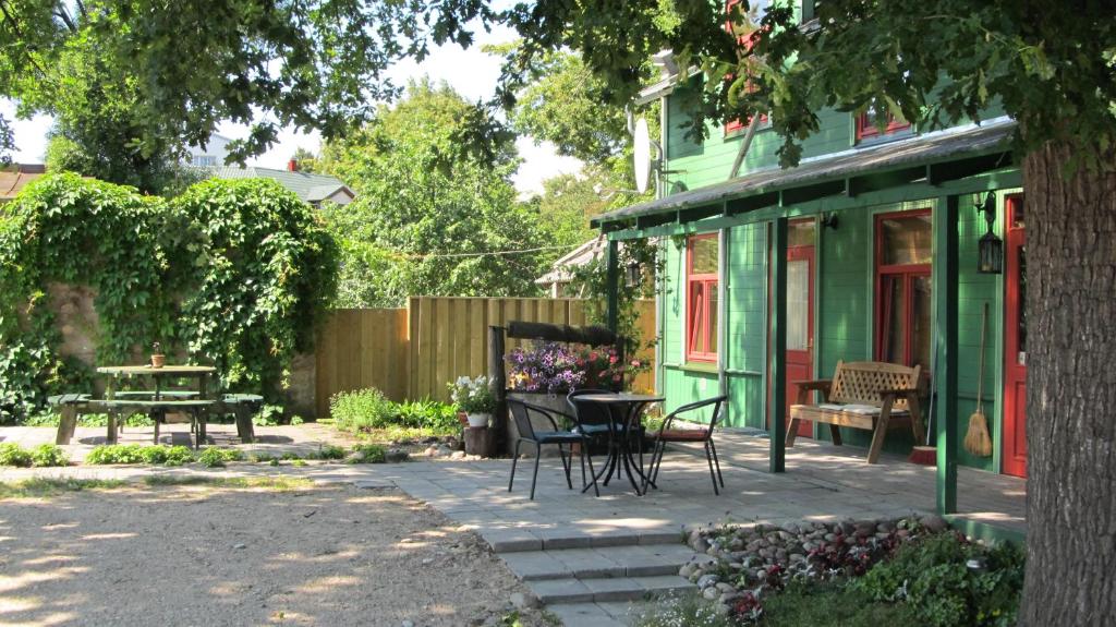 un patio con mesa y sillas junto a una casa en Raibie Logi, en Ventspils