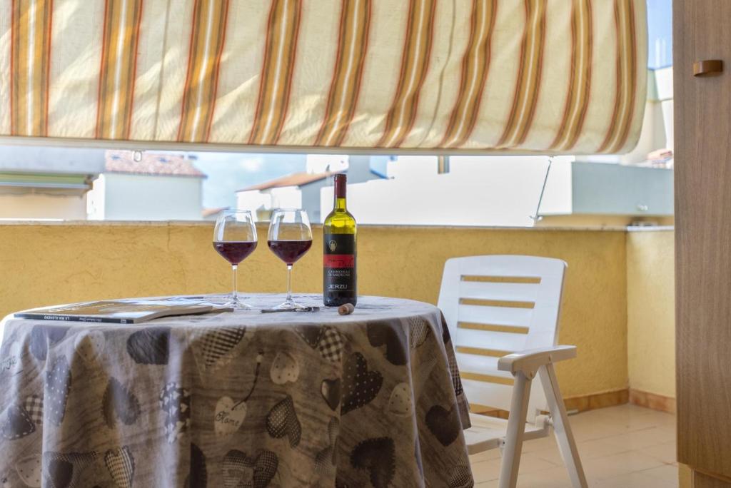 una mesa con dos copas de vino. en Red Passion Beach, en Alghero