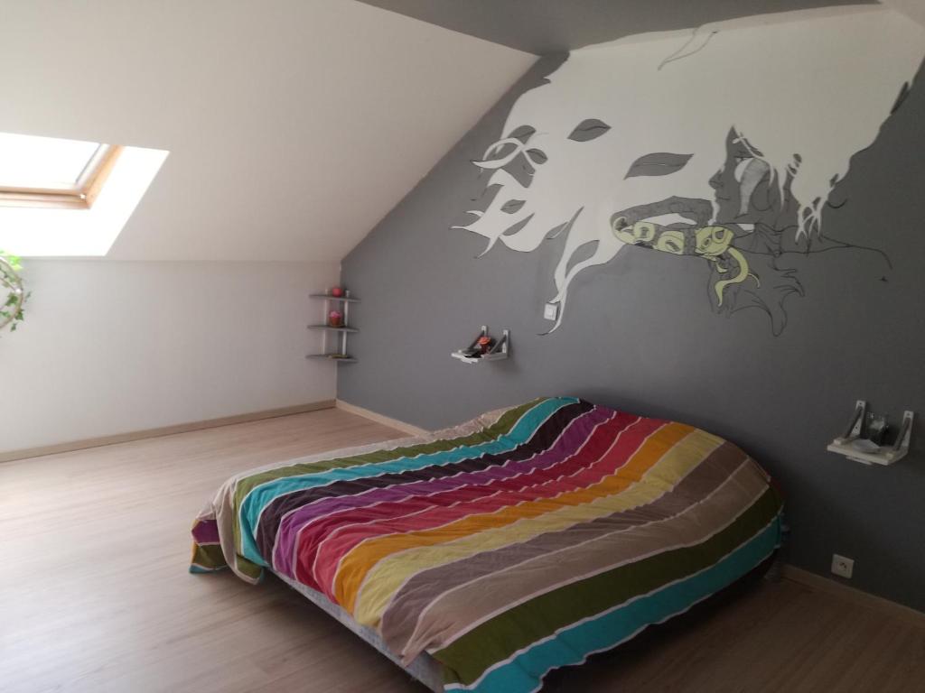 een slaapkamer met een bed met een koeienmuurschildering aan de muur bij Chambre à Villemandeur Chez L'habitant in Villemandeur