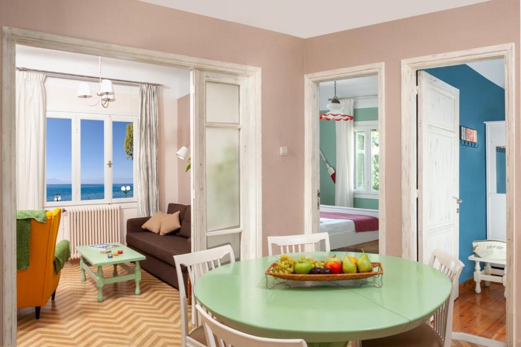 a living room with a table with a bowl of fruit at Avgi by the Sea in Kala Nera
