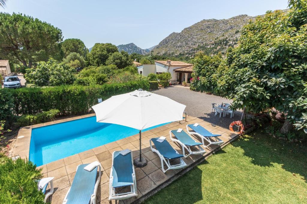 a swimming pool with chairs and an umbrella at Villa Rosa in Pollença
