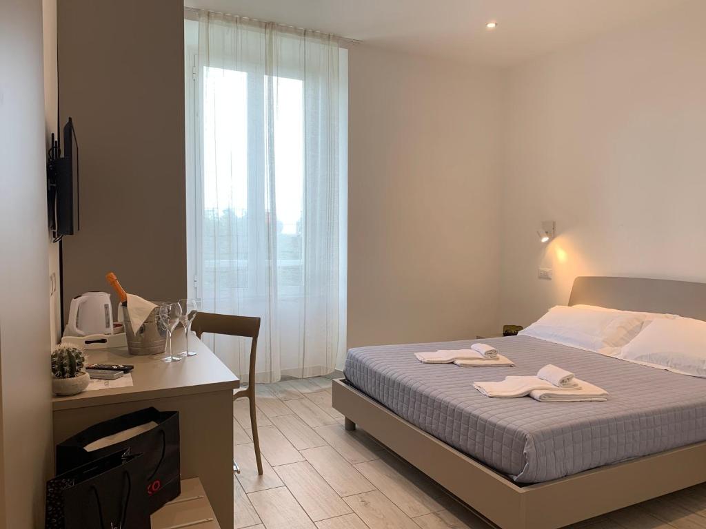 1 dormitorio con cama, escritorio y ventana en Affittacamere Sapore di Mare, en Levanto