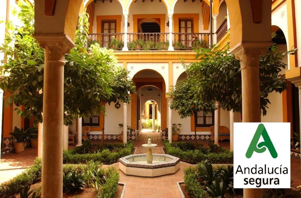 a courtyard in an old building with a fountain at Hotel Casa Imperial in Seville