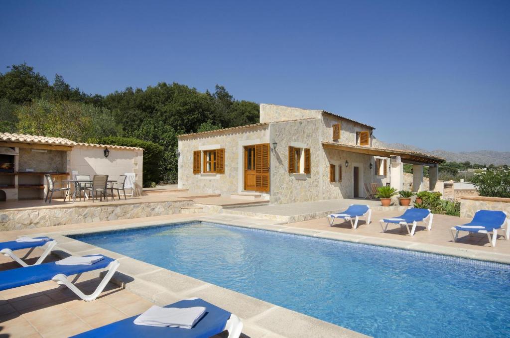 a villa with a swimming pool and a house at Villa Varella in Pollença