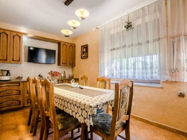 a kitchen with a table with chairs and a television at Magnollia in Grębocin