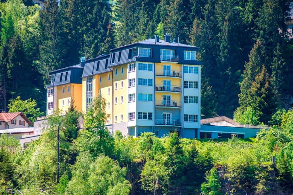 a building on the side of a hill with trees at Sonnenwende by AlpenTravel in Bad Gastein