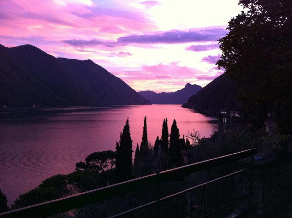 a view of a lake at sunset with mountains at Villa Bianca in Valsolda