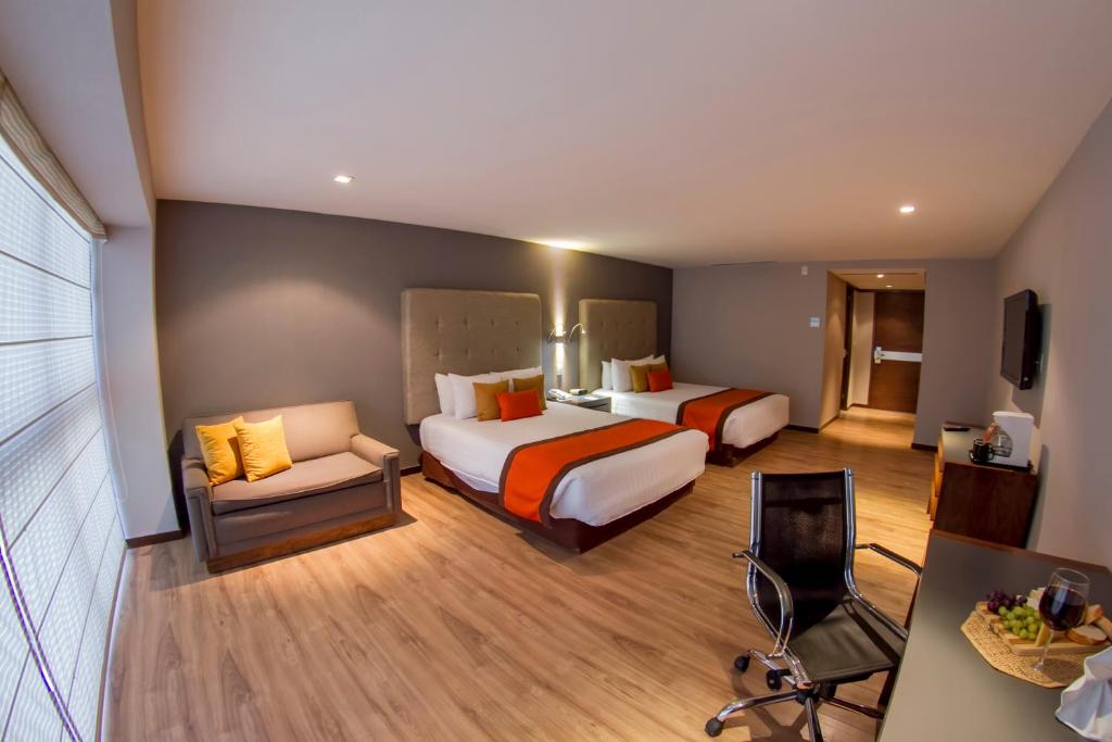 een hotelkamer met 2 bedden en een stoel bij El Diplomatico in Mexico-Stad