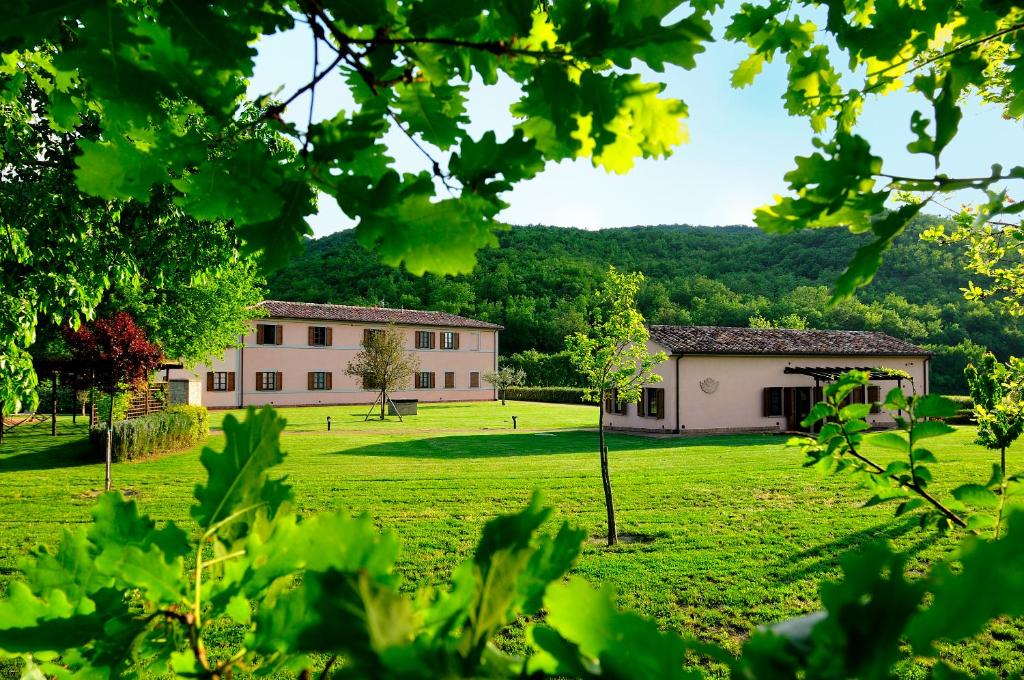een gebouw in een veld met een gebouw op de achtergrond bij Agriturismo il Corniolo in Cenerente
