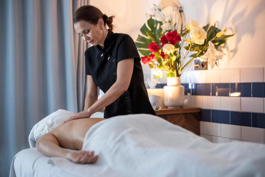 a woman sitting on a bed with a patient at L'Eautel Toulon Centre Port in Toulon