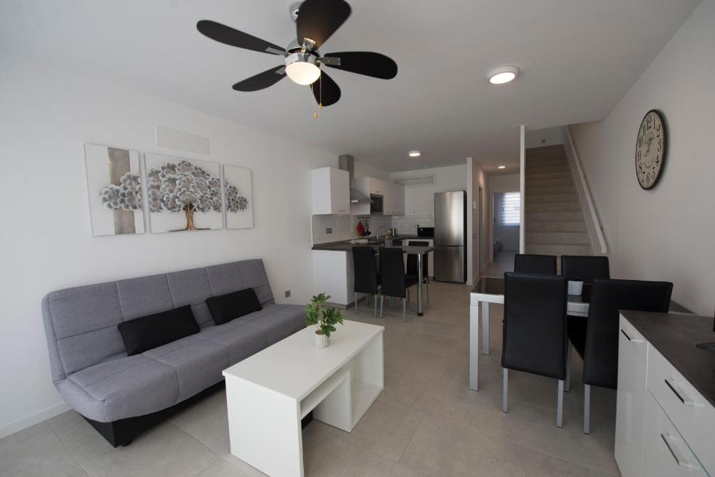 ein Wohnzimmer mit einem Sofa und einem Deckenventilator in der Unterkunft Casa Reina in Playa Blanca
