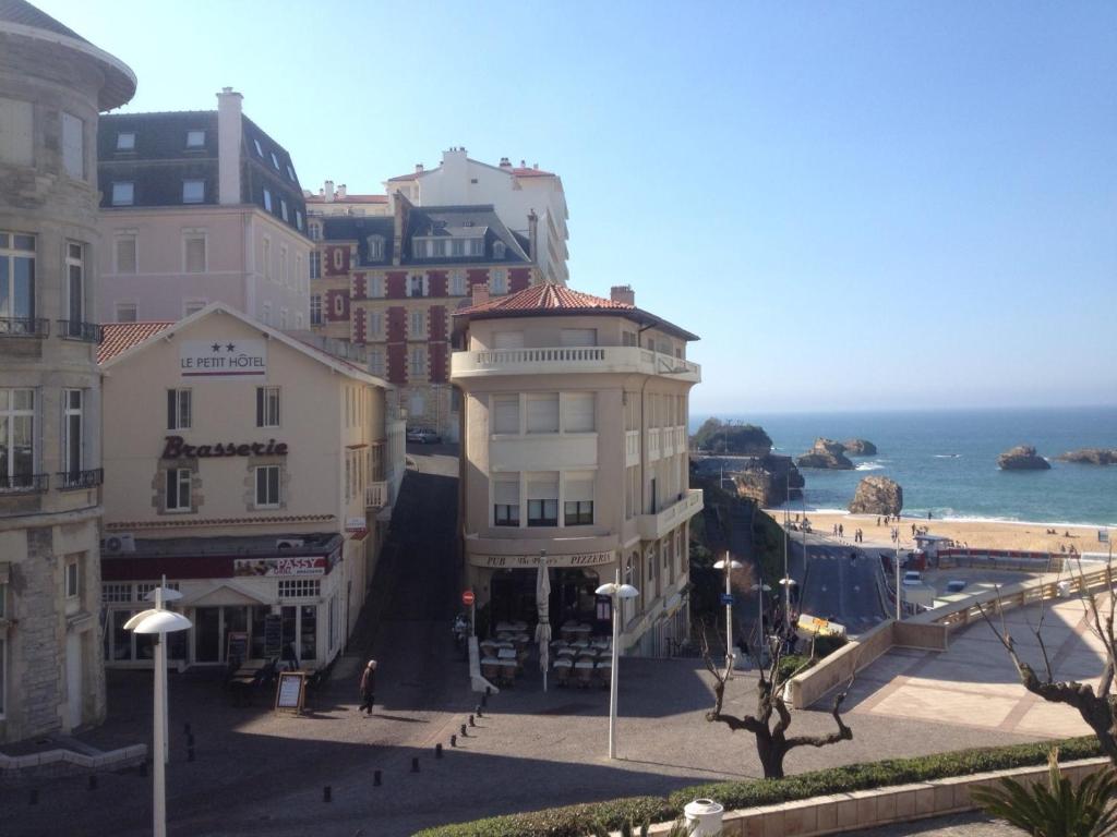 eine Gruppe von Gebäuden auf einer Straße neben dem Meer in der Unterkunft Le Petit Hôtel in Biarritz