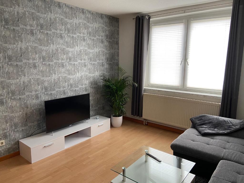 a living room with a couch and a flat screen tv at Cottbuser City Ferienwohnung in Cottbus