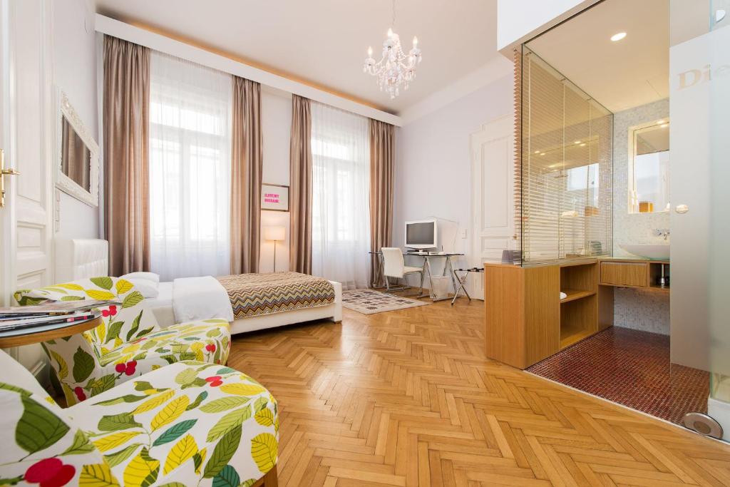 Habitación de hotel con sala de estar y dormitorio en Rosa Linde - Comfort Rooms, en Viena