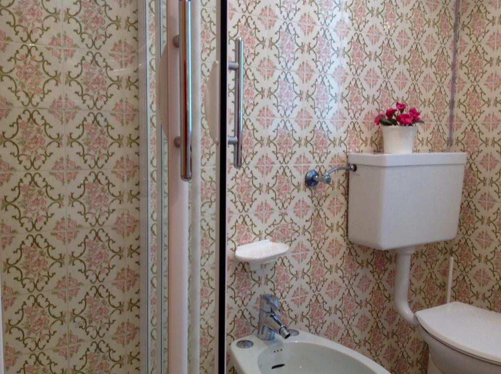 2 immagini di un bagno con servizi igienici e lavandino di Serena Rustic a Ledro