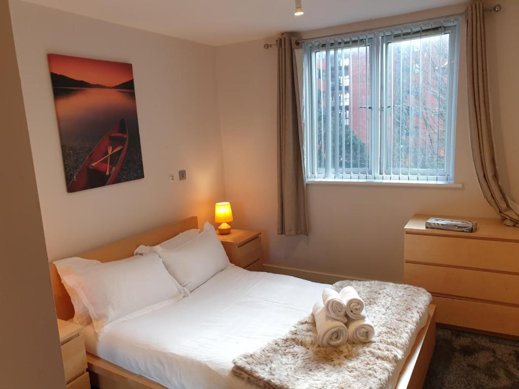 伯明罕的住宿－Birmingham Emerald, 2 bedroom Apartment，一间卧室配有一张床,上面有两条毛巾