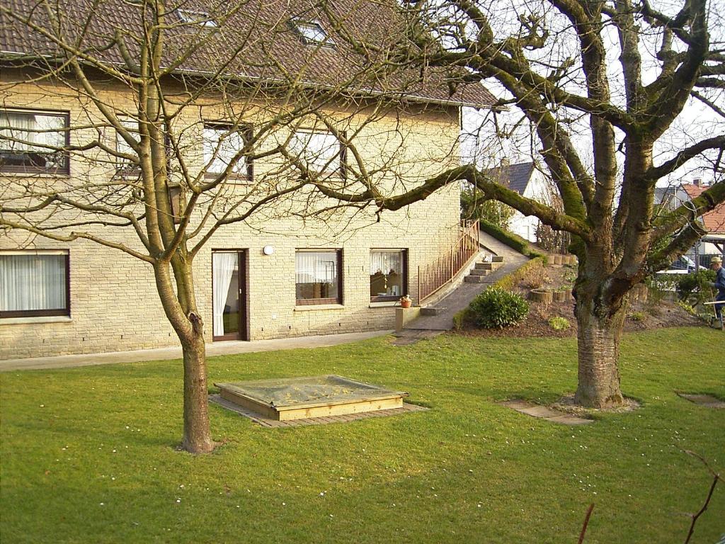 una casa con una rampa en un patio con dos árboles en Ferienhaus und Ferienwohnung Knappstein, en Möhnesee