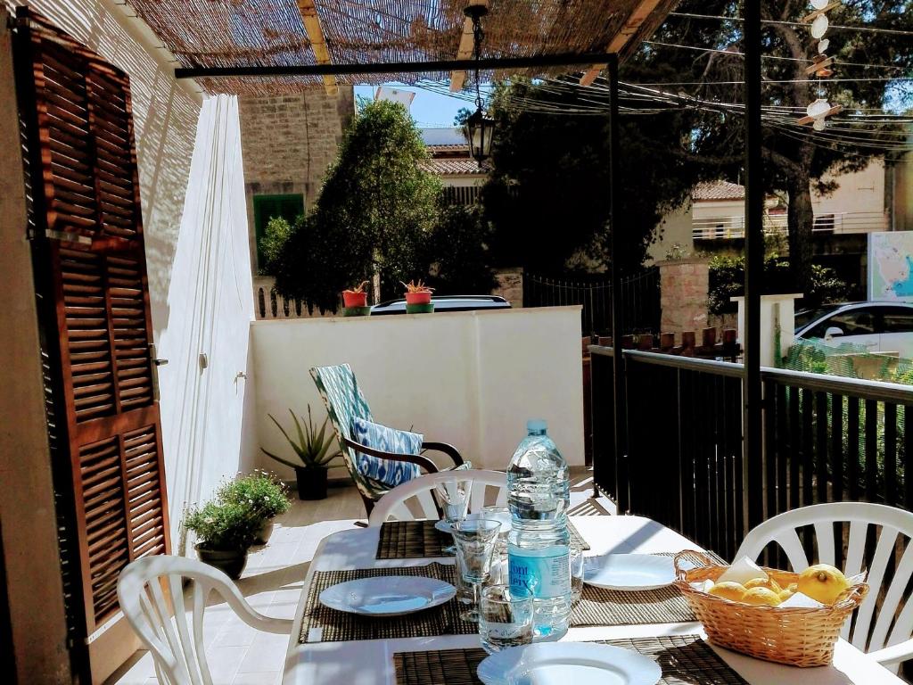 un tavolo con sedie e una bottiglia d'acqua su un patio di Sa Cala Beach House a Cala Figuera