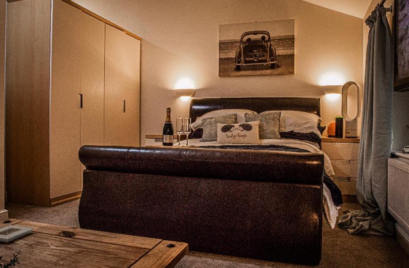 1 dormitorio con 1 cama en una habitación con mesa en Log cabin, en Coventry