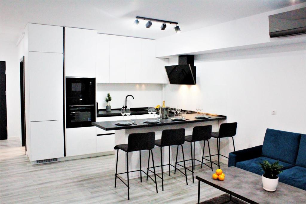 uma cozinha e sala de estar com um balcão e bancos em WHITE VIBE em Cluj-Napoca