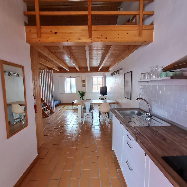 een keuken met een wastafel en een tafel met stoelen bij Casas Alba Odeceixe in Odeceixe