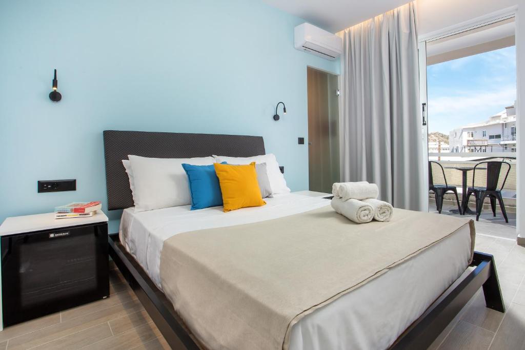 1 dormitorio con 1 cama grande y balcón en Faliraki Premium Hotel en Faliraki