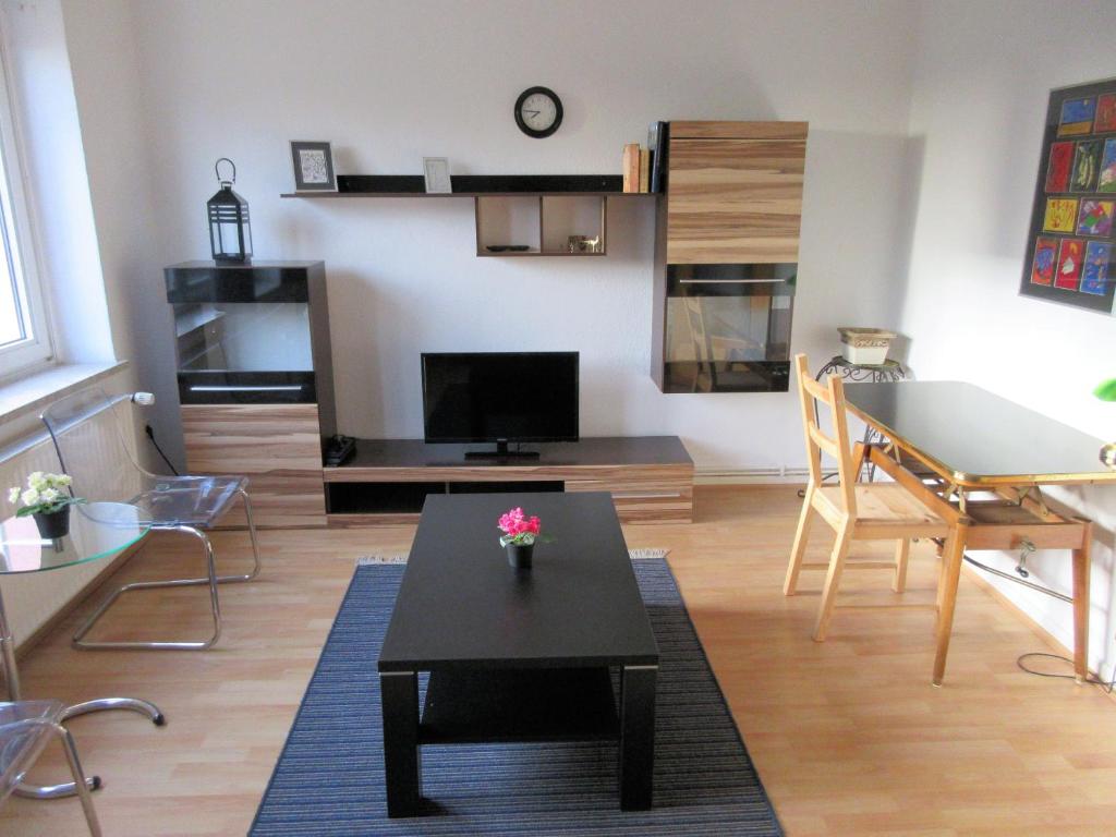 ein Wohnzimmer mit einem Tisch und einem Esszimmer in der Unterkunft Studio Apartment - Messe Nord in Hannover
