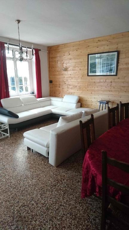 Gîte des bords de Rance في Langrolay: غرفة معيشة مع أرائك بيضاء وأريكة