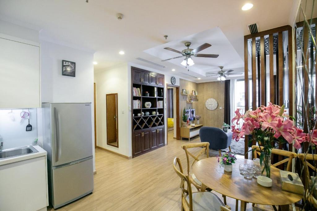 Il comprend une cuisine et une salle à manger avec une table et un réfrigérateur. dans l'établissement BOM HOMES- Vinhomes Times City- Service Apartment, à Hanoï