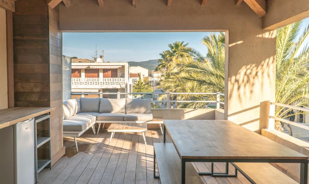 patio con sofá y mesa en el balcón en La Palmeraie Galli - Duplex de Charme, en Sanary-sur-Mer