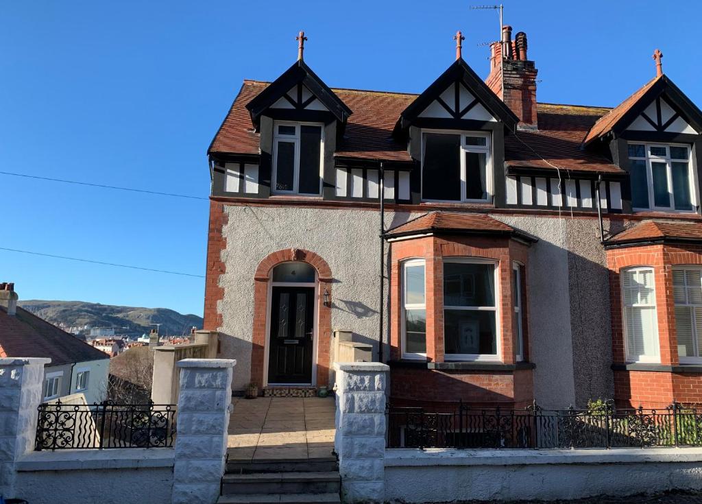 a large brick house with a front porch at 4 Tan Y Bryn Road in Llandudno