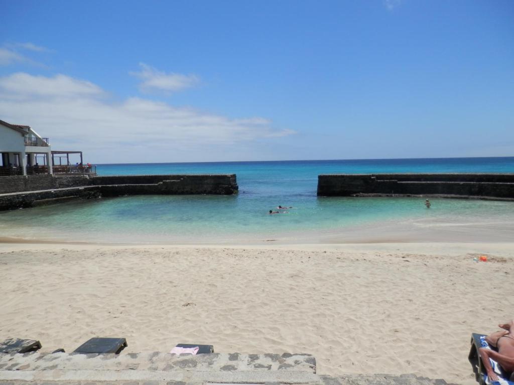 una playa con gente nadando en el agua en Private Apartments 1 minute to the pool & beach Santa Maria #74B #86, en Santa Maria