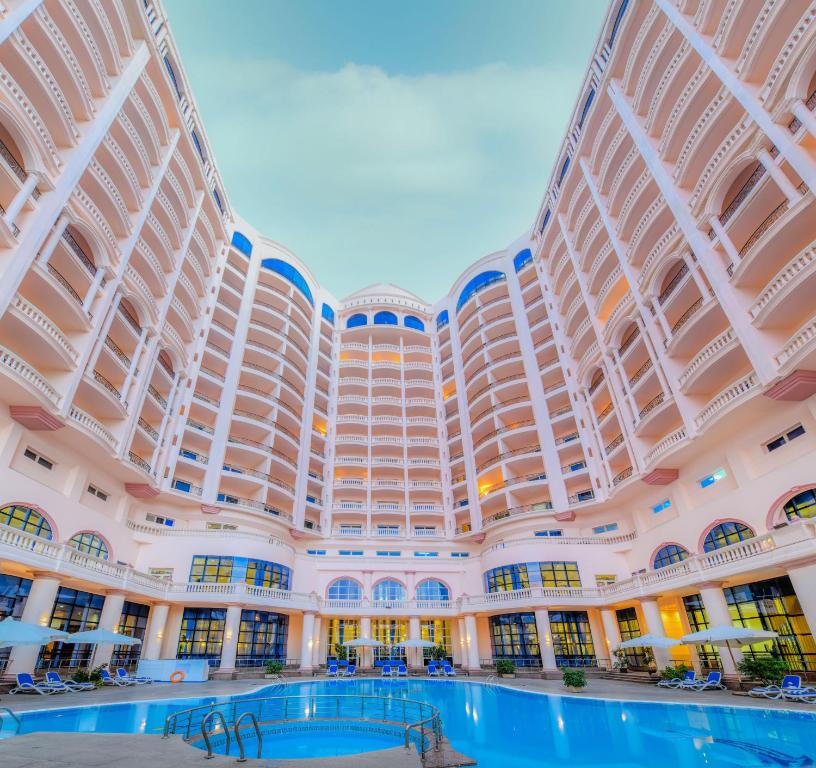 un grande edificio con piscina di fronte di Tolip Hotel Alexandria ad Alessandria d'Egitto