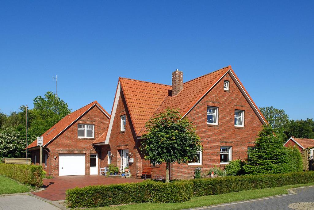 una gran casa de ladrillo marrón con garaje blanco en Ferienwohnung Wattgeflüster, en Esens