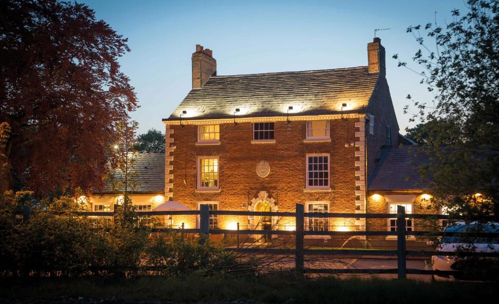 a large brick building with lights on it at The Partridge, Stretton in Stretton