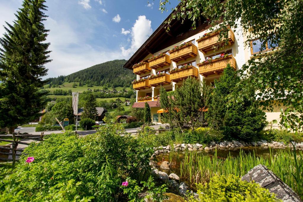 un hôtel avec un jardin en face d'un bâtiment dans l'établissement Family & Sporthotel Kärntnerhof, à Bad Kleinkirchheim