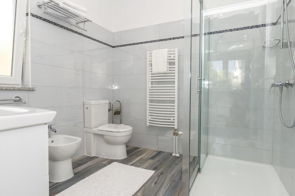 W łazience znajduje się toaleta i przeszklony prysznic. w obiekcie Beachfront Holiday House Kaliope w mieście Brgulje