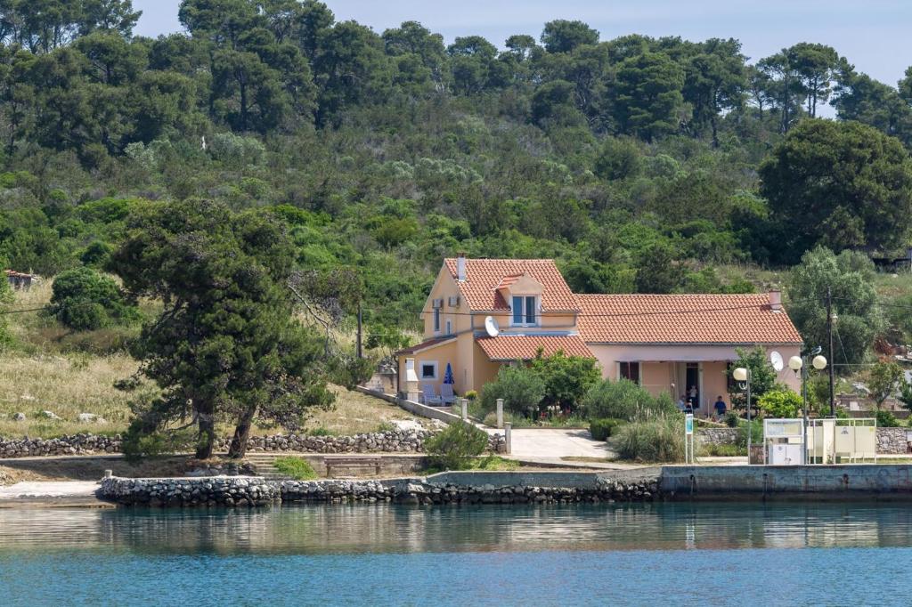 ein Haus am Ufer eines Wasserkörpers in der Unterkunft Beachfront Holiday House Zita in Brgulje