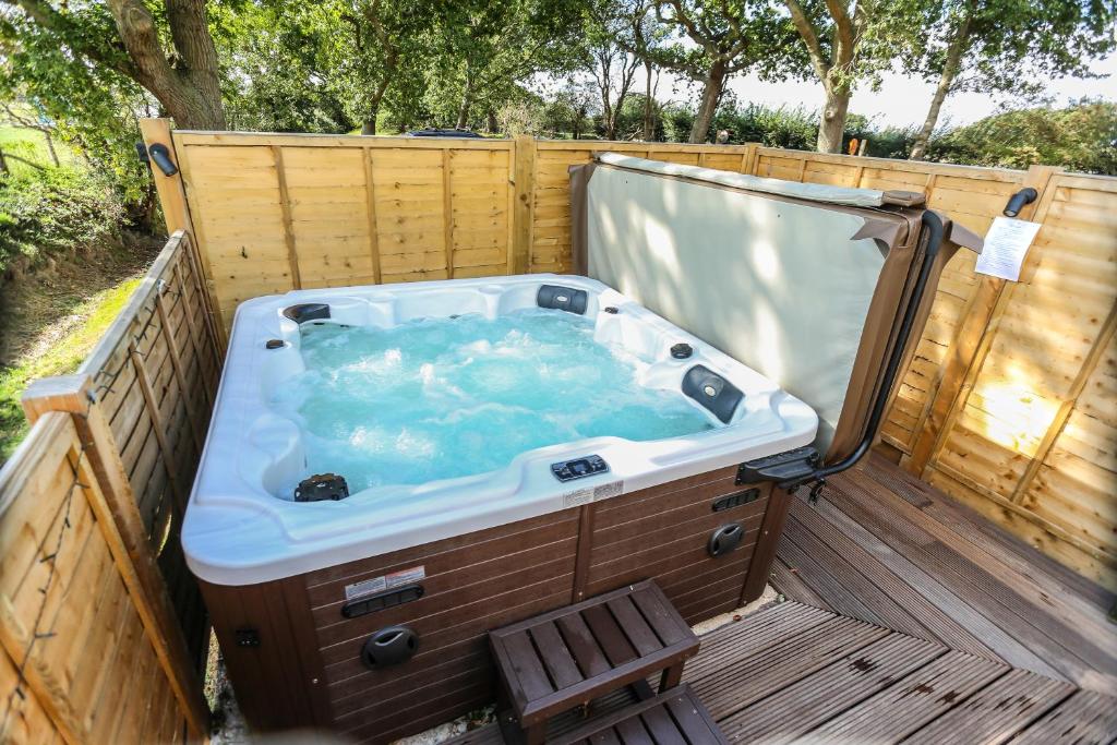 a jacuzzi tub on a wooden deck at Linden House in West Wittering