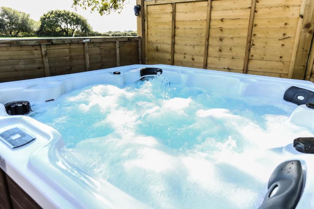 a jacuzzi tub filled with blue water at Linden House in West Wittering
