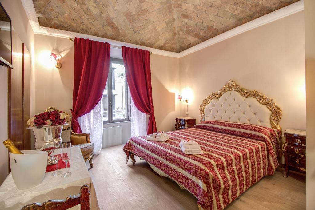 um quarto com uma cama com uma colcha vermelha em La Reggia dei Principi em Roma