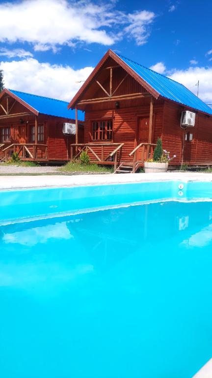 una casa con piscina frente a ella en Cabañas Antawara Uspallata en Uspallata
