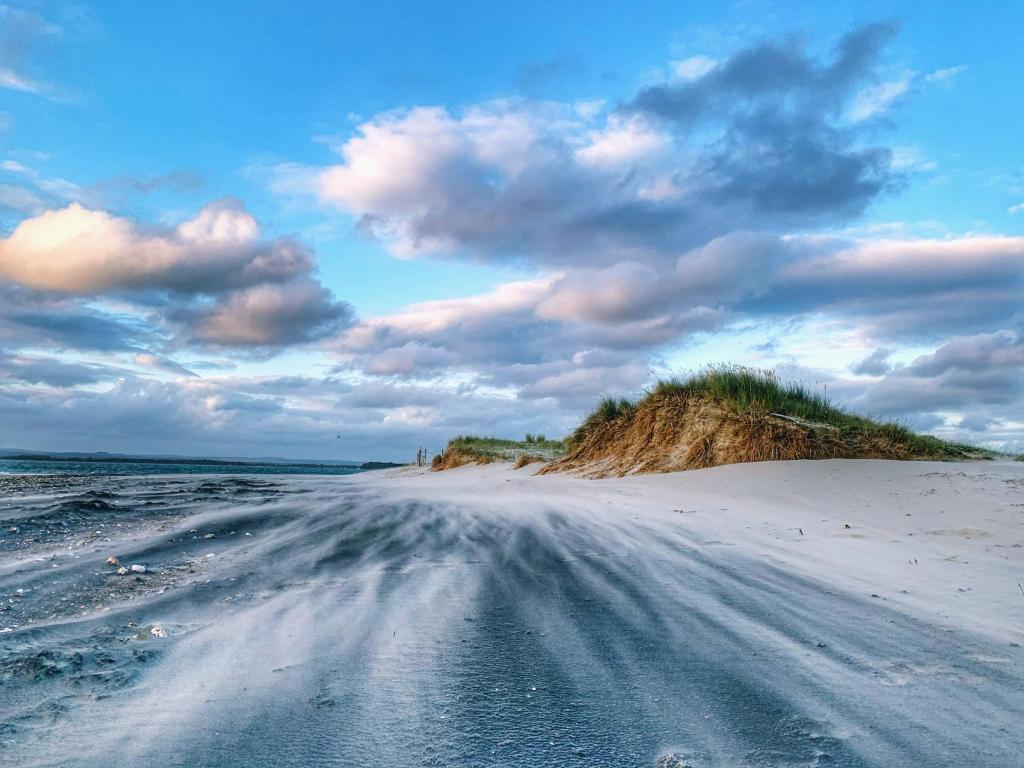 a dirt road in the middle of a beach at Linden House in West Wittering